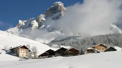 Typische ladinische Bauernhöfe mit dem Lavarella Berg (3.055 m)