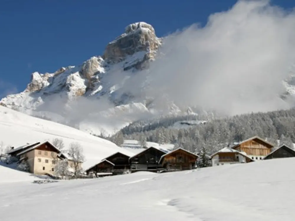Typische ladinische Bauernhöfe mit dem Lavarella Berg (3.055 m)