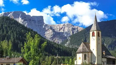 Blick auf die Pfarrkirche St. Veit in Prags mit den Dolomiten im Hintergrund