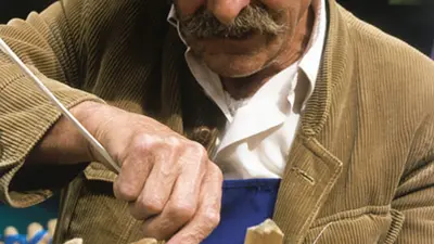 Älterer Mann beim Korbflechten