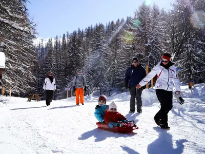 Familie auf dem Weg zum Rodeln © Jan NOVAK / OTI Pays des Écrins