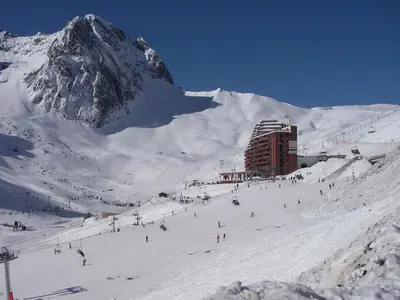 Piste in La Mongie mit Sessellift und Bergstation © Zyonig via Wikimedia Commons