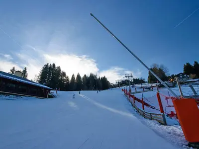 Piste mit Skifahrer und Beschneiungsanlage © OT Morillon Grand Massif / J.-C. Laurent