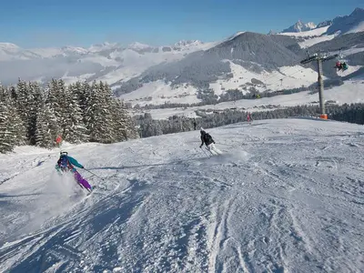 Zwei Skifahrer auf der Piste mit Sessellift © Megève Tourisme - Nicolas Joly