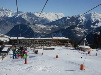Sessellift mit Skifahrern über dem Skigebiet © Corbier Tourisme_IMC
