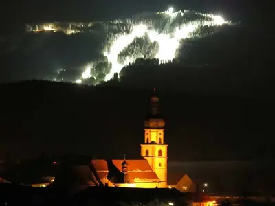 Beleuchtete Wallfahrtskirche mit der beleuchteten Piste im Hintergrund © Hohenbogenbahn GmbH