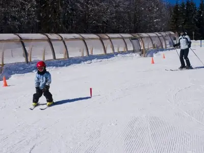 Kind vor überdachtem Förderband © Skizentrum Mitterfirmiansreut-Philippsreut
