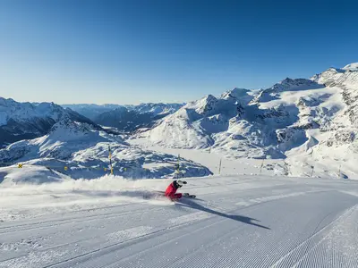 Skifahrer beim Carven. Im Hintergrund der verschneite Lago Bianco und das Puschlav. © Engadin St. Moritz / Gian Andi Giovanoli