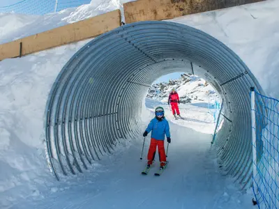 Ein Kind fährt durch einen Tunnel auf der Family Funslope auf der Fischeralp &nbsp; © aletscharena