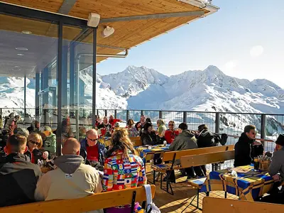 Menschen bei der Einkehr auf einer Sonnenterrasse am Sonnenkopf © Klostertaler Bergbahnen