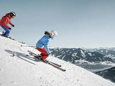 Zwei Skifahrer bei der Abfahrt auf der Piste in Schmitten © Schmittenhöhebahn AG