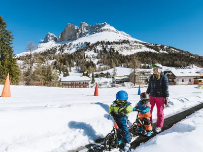 Kinder auf einem Förderbahn im Skigebiet Carezza © Carezza Dolomites/StorytellerLabs