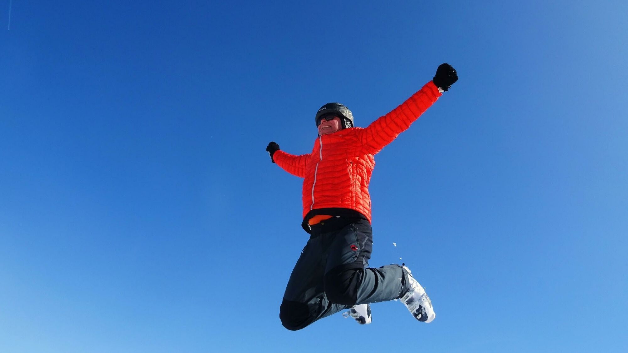 Ein Skifahrer springt vor Freude in die Luft
