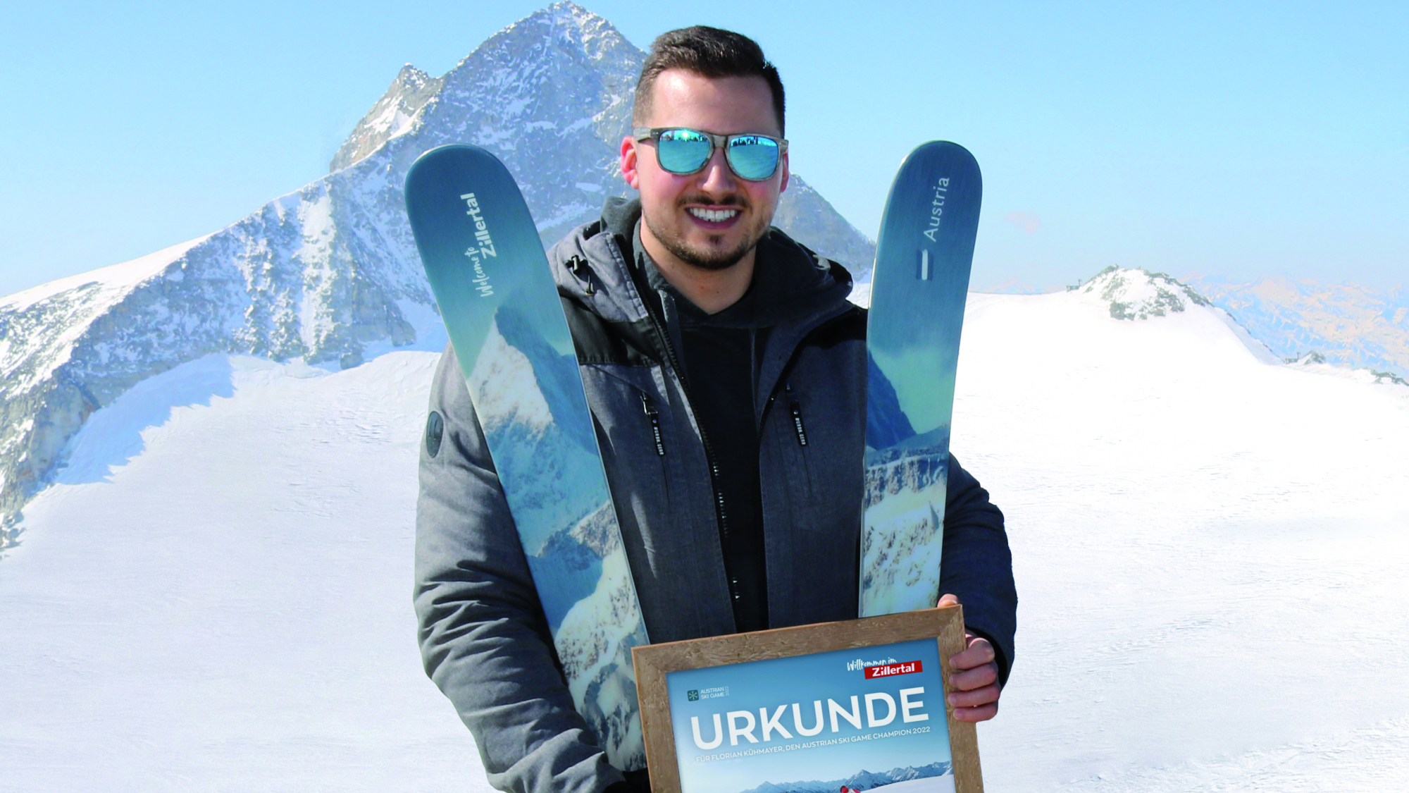 Der strahlende Gewinner Florian Kühmayer bei der Gewinnübergabe vor dem Olperer dem Motiv auf seinem