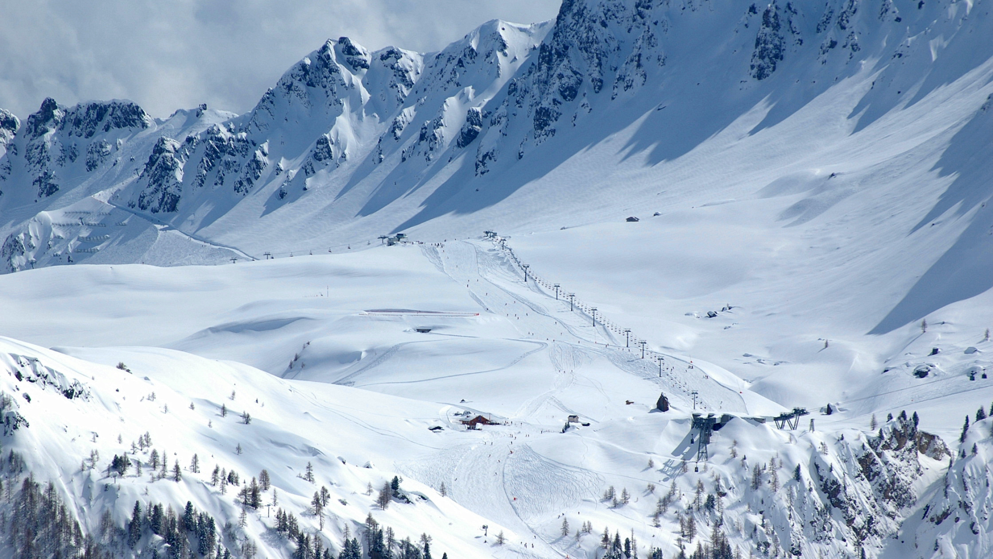 Der Verbindungssessellift „Sass de la Vegla“ (Bildmitte) ist das Nadelöhr auf dem Weg von Arabba über den Padon Pass (2370m; ganz links) nach Malga Ciapela (1450m)