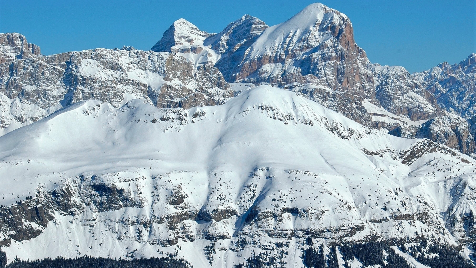 Vom Verbindungssessellift „Sass de la Vegla“ kann man in direkter Linie über den Col di Lana (2462m) zum Dreigestirn der Tofane (3244m) blicken, fast in Bildmitte erkennt man auch die Bergstation der Lagazuoi-Seilbahn (2742m)Vom Verbindungssessellift „Sass de la Vegla“ kann man in direkter Linie über den Col di Lana (2462m) zum Dreigestirn der Tofane (3244m) blicken, fast in Bildmitte erkennt man auch die Bergstation der Lagazuoi-Seilbahn (2742m)