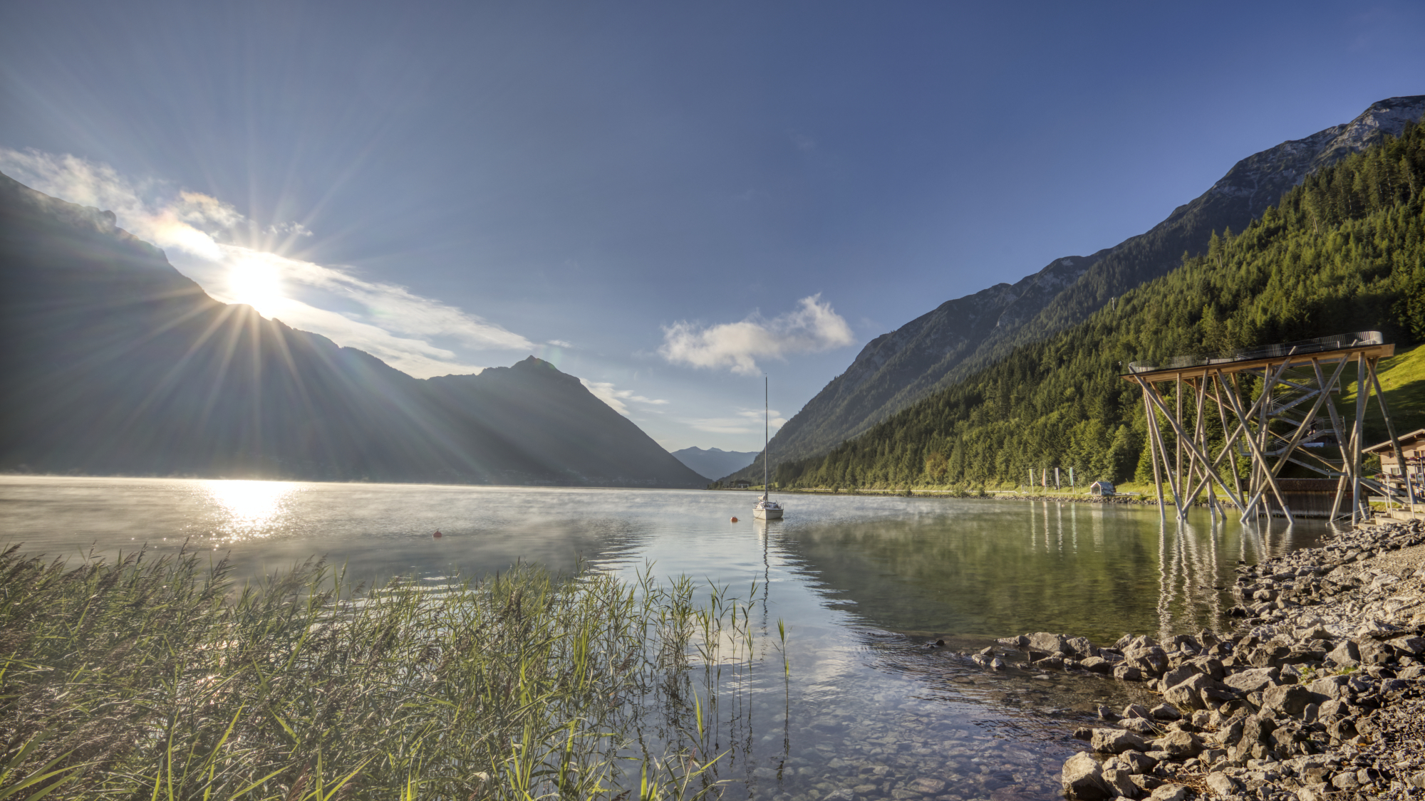 Von Pertisau aus erstreckt sich der Blick über den Achensee bis hin nach Maurach. Auffallend ragt dabei das Ebner Joch ins Auge. Im rechten Bereich des Bildes ist zudem der Hochsteg deutlich erkennbar.
