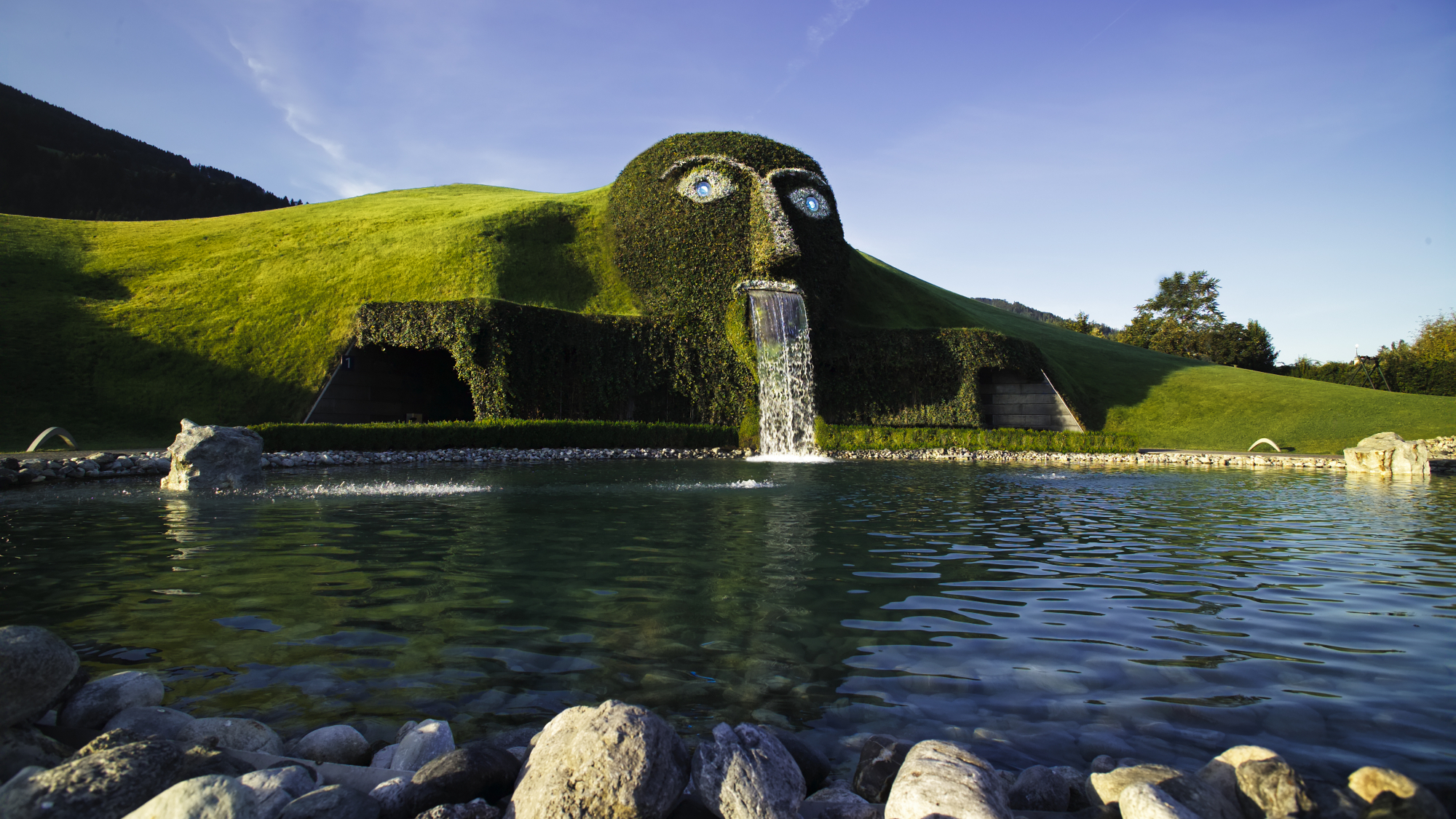 Mit funkelnden Augen und einem Wasser speienden Mund empfängt der Riese die Besucher:innen der Swarovski Kristallwelten in der Nähe von Innsbruck.