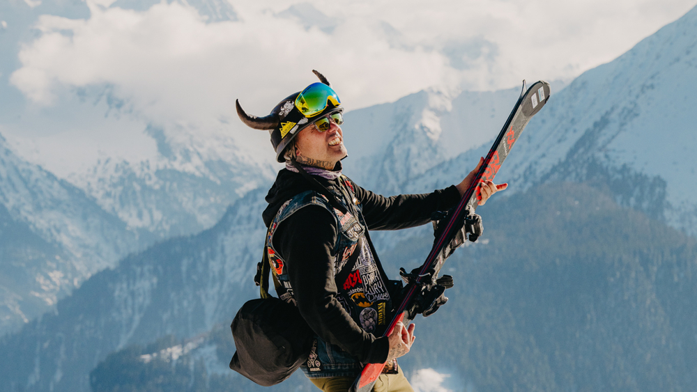 Metalpose vor Bergkulisse