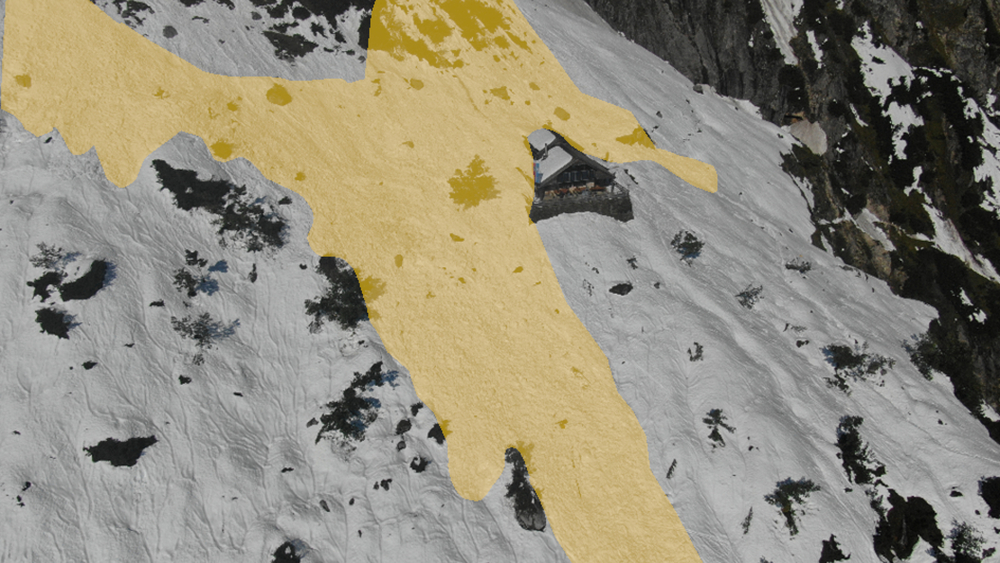 Drohnenaufnahme der Toni-Lenz-Hütte vom 20.09.2024 wenige Tage nach dem Lawinenabgang, der kleinere Schäden an der Hütte verursachte; gelbe Farbmarkierung stellt den ungefähren Ablagerungsbereich dar. 