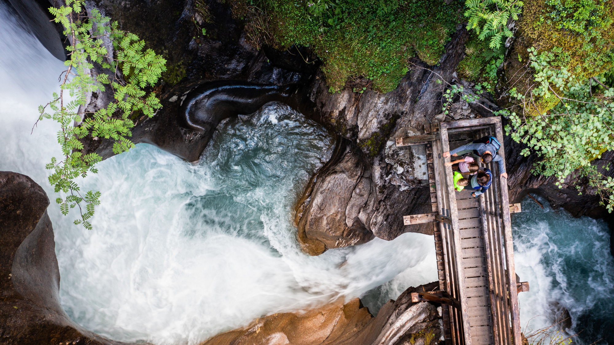 Wanderer auf Brücke über Klamm