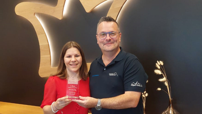 Verena Eichinger, Leitung Marketing & Eventmanagement bei der Hochkönig Tourismus GmbH nimmt von Christopher Lahm-Wolter den Preis entgegen