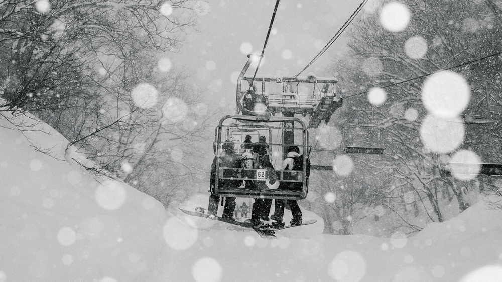 BETWEEN DAYS - Fahrt im Sessellift bei Schneegestöber