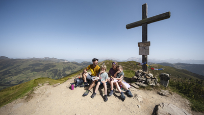 Familie macht Pause am Gipfelkreuz