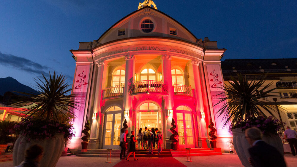 Das beleuchtete Kurhaus in Meran am Abend