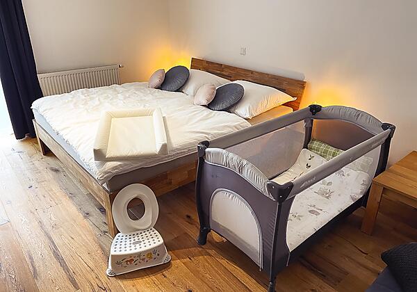 Schlafzimmer mit Babybett und Babyausstattung