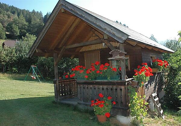 Gartenhütte mit Schaukel im Hintergrund
