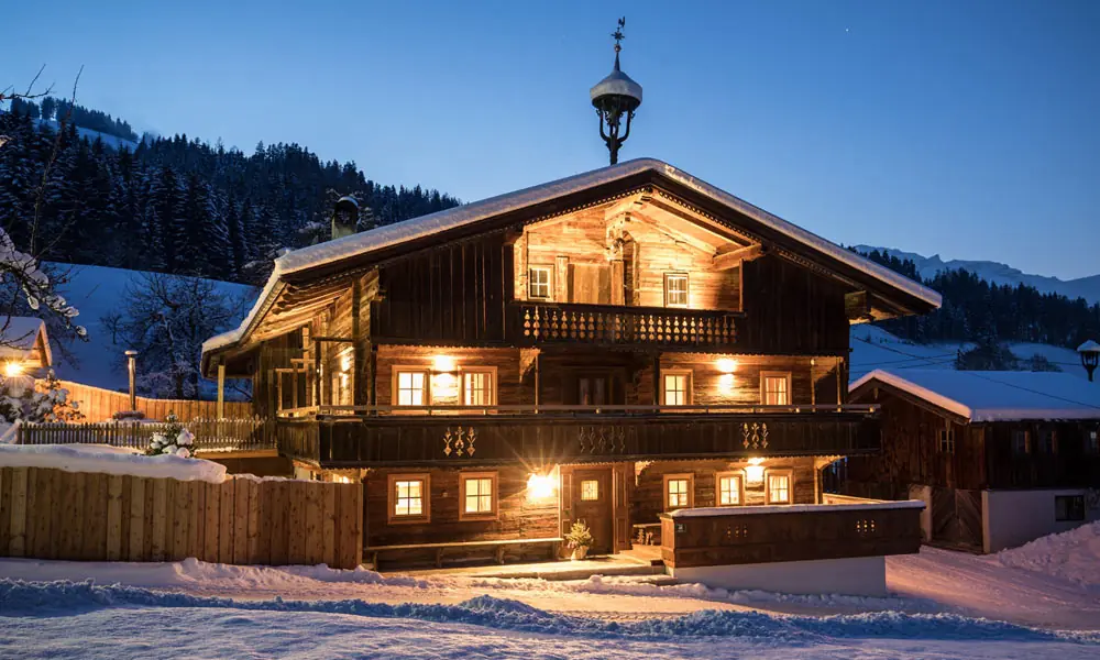 Blick auf das winterliche Bergchalet Rauchenhof in Reith