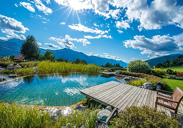 Der hoteleigene Naturschwimmteich mit tollem Bergpanorama