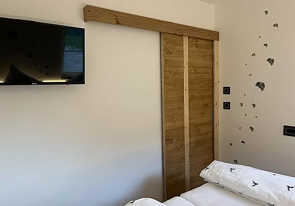 Schlafzimmer mit Zirbenbett und Sat-TV