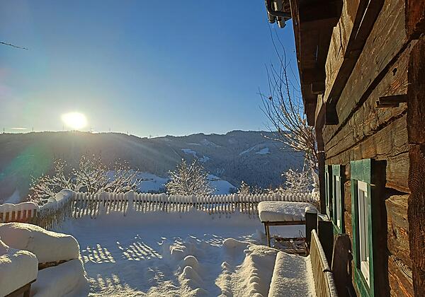 Wintersonne auf der Terrasse der Almhütte Brandgut