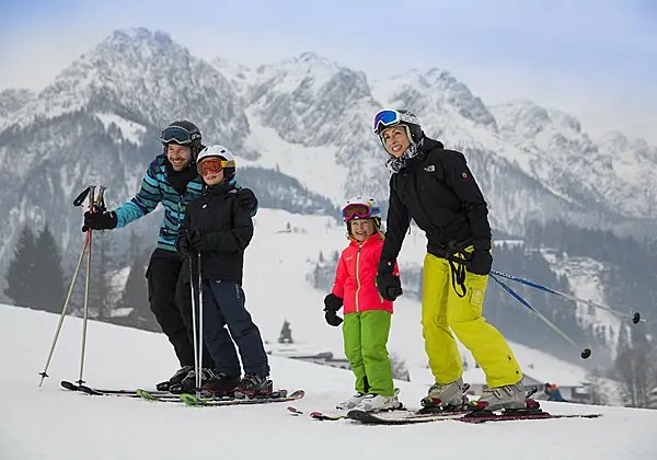 Eine Familie mit 2 Kindern beim Skifahren