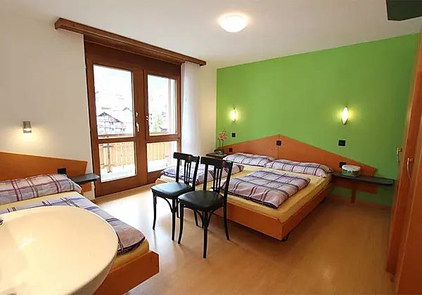 Das Schlafzimmer 1 mit Balkon von der Ferienwohnung 2 im Ferienhaus-Apartment Golf