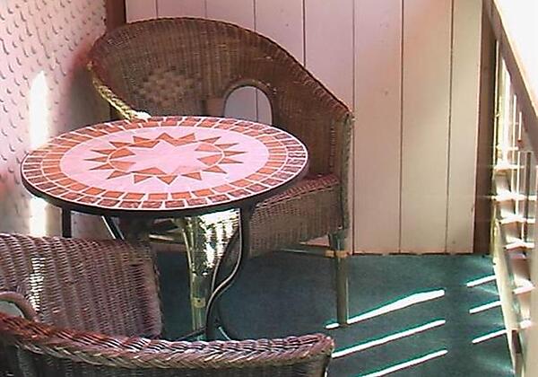 Balkon: Tisch mit Korbstühlen