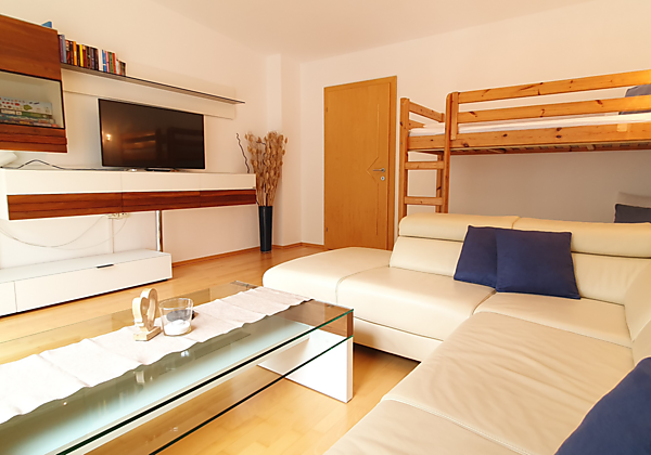 großer separater Wohnraum mit Sofa und Etagenbett