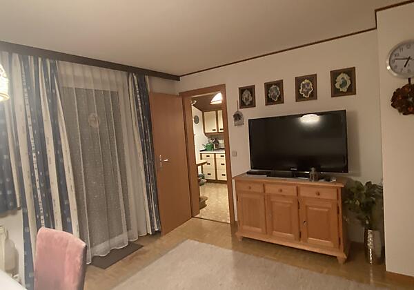 Wohn-Esszimmer mit Balkon und großen TV-Bildschirm