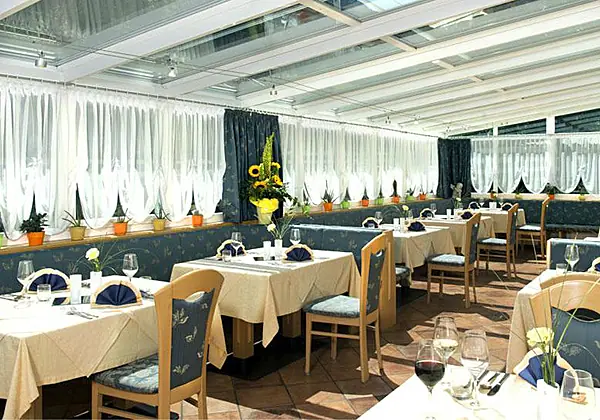 Der gemütliche Speisesaal mit Wintergarten im Hotel Bergblick in Ratschings