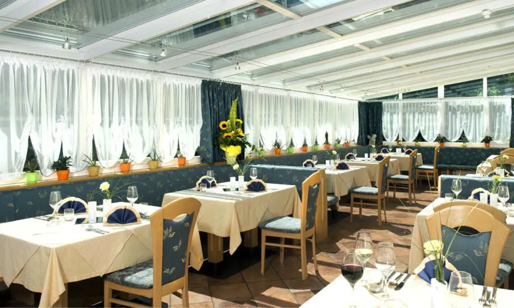 Der gemütliche Speisesaal mit Wintergarten im Hotel Bergblick in Ratschings