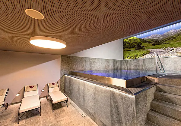 Das Hallenbad mit Ruheliegen im Hotel Universo in Serfaus