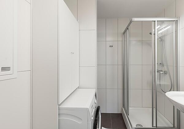 Badezimmer mit Dusche und Waschmaschine